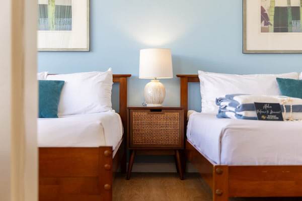 Sleep in comfort with a stylish nightstand and a modern lamp conveniently located between the beds.