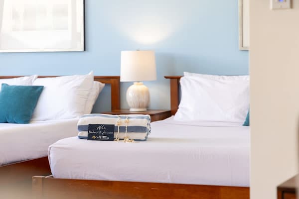 Sleep in comfort with a stylish nightstand and a modern lamp conveniently located between the beds.