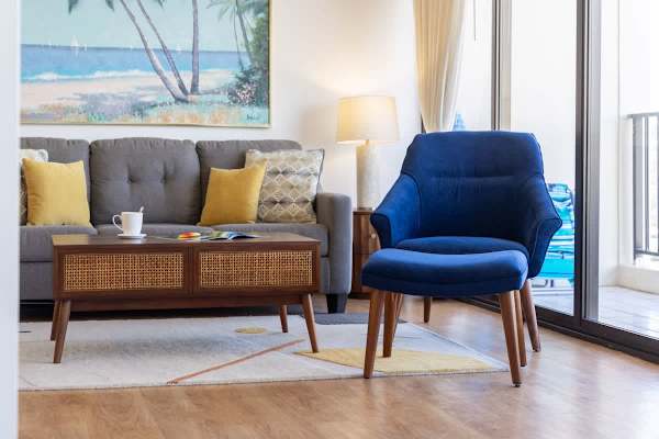 Relax in the bright, modern living room that features a comfortable sofa and a stylish accent chair, with seamless access to the balcony.
