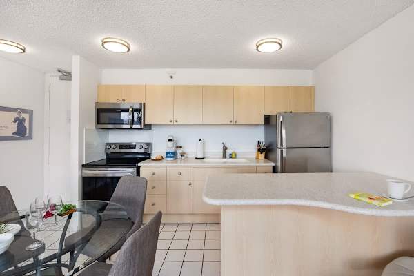 Cook with ease in the fully-equipped kitchen, featuring stainless steel appliances, a dining table with 4 chairs, and a breakfast bar for casual dining.