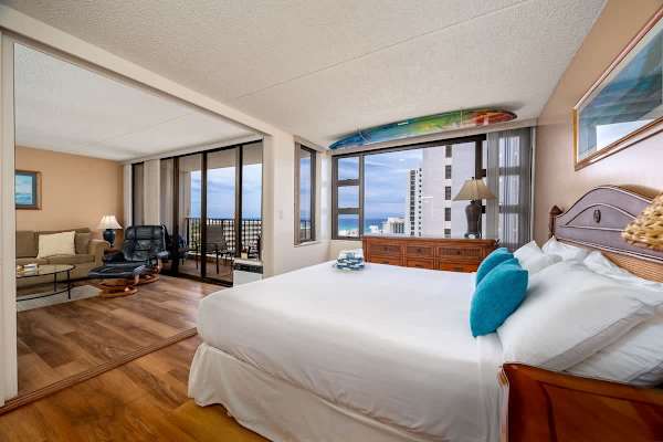 Indulge in ultimate comfort in your bedroom featuring a king-size bed, offering stunning direct ocean views from your window. The bedroom is separated from the living room by a sliding door.