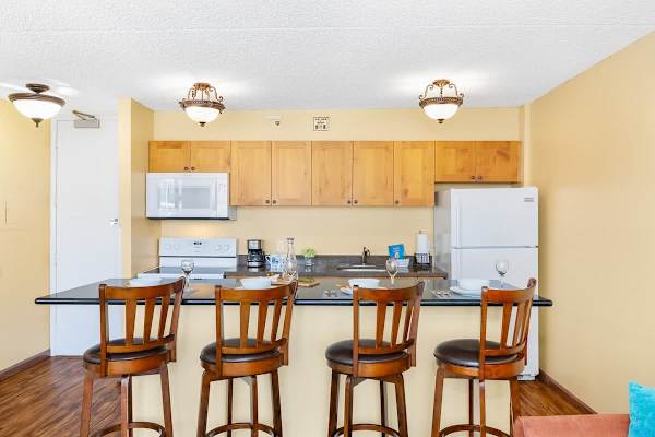Fully equipped kitchen and kitchen counter with 4 bar stools.