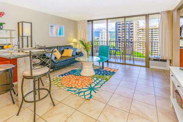 Living room with open kitchen, reclining sleeper sofa, and window AC