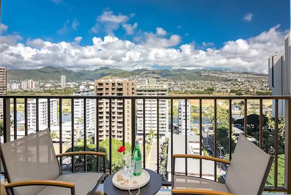 Relax on the balcony with city and mountain views in a modern setting.