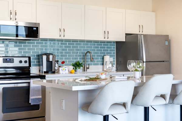 Modern kitchen with stainless steel appliances and a blue tile backsplash