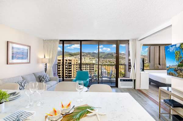 Bright living area with mountain views and a balcony seating area.