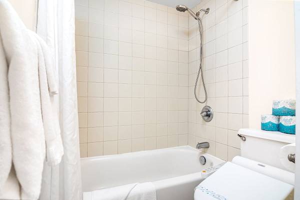 Clean bathroom with a tiled shower and bathtub combination.