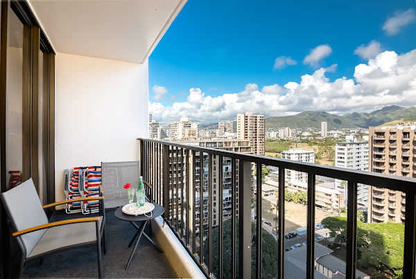 Relax on the balcony with city and mountain views in a modern setting.