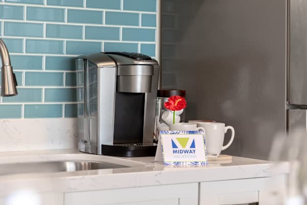 Modern coffee maker set against a blue tiled backsplash in the kitchen