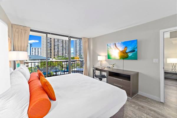 Bedroom with a king-size bed, dedicated workspace, and a flatscreen TV.