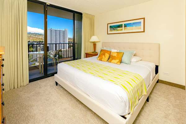 Bright bedroom with a balcony offering city and mountain views