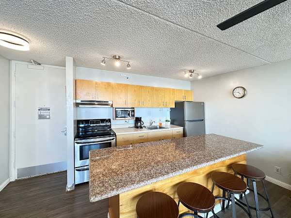 The fully equipped kitchen with full-size appliances and the dining area with 4 bar stools.