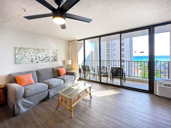 Living with pull-out sleeper sofa, coffee table, ceiling fan, air-conditioning, and a flat-screen TV.