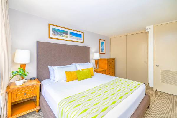 Bedroom with King-size bed, dresser and TV. 