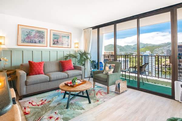 Living room with pull-out sleeper sofa, accent chair, coffee table, air conditioner, and mountain view.