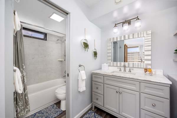 Refresh in this bright and modern bathroom, featuring a stylish vanity with ample counter space, a large mirror, and a convenient shower-over-tub combination, all designed for your comfort.