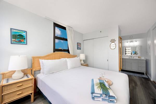 Relax in the bedroom featuring a king-size bed, charming rattan nightstands, and convenient access to the modern en-suite bathroom.