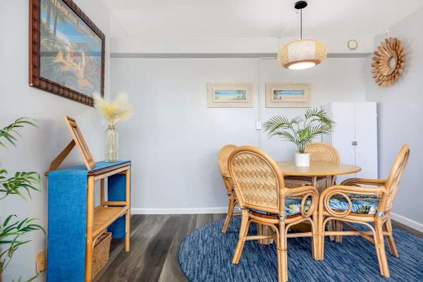Gather for meals in this charming dining area, featuring a round table with 4 tropical-inspired chairs, set atop a stylish blue rug and adorned with tasteful island-themed decor.