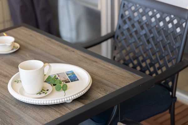 A balcony with an outdoor dining table and chairs, offering a bright and inviting space to relax.