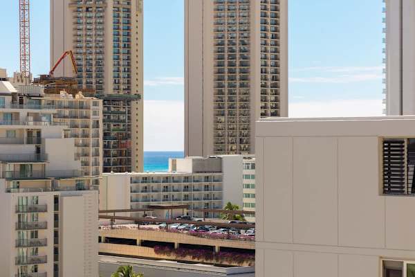Enjoy stunning views of the city skyline and a glimpse of the ocean from your balcony.