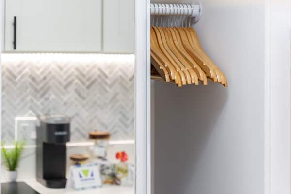 Closet with a row of wooden hangers, showcasing ample storage space.