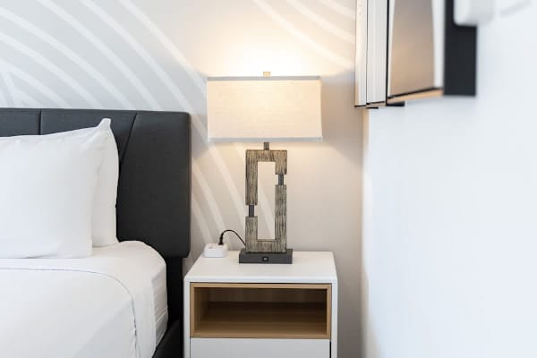 A stylish nightstand with a unique lamp and a USB charging port, perfect for keeping your devices powered up.