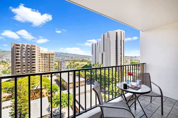Step onto your private balcony and soak in the expansive mountain and city views under a bright blue sky.