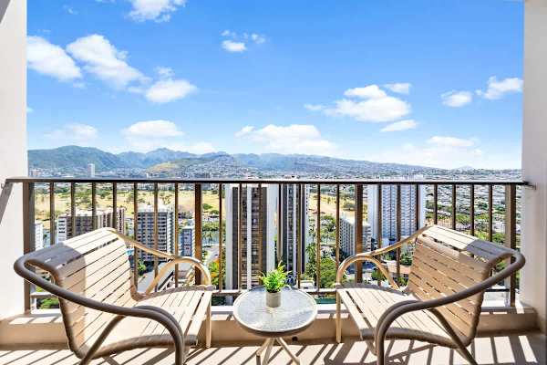 Enjoy a breathtaking breakfast or sunset cocktail on the private balcony with expansive views of the city skyline and majestic green mountains.
