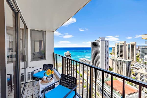 Relax on the balcony with ocean and city views in this modern high-rise apartment.