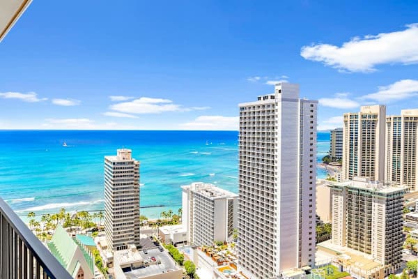 Ocean view from a high-rise balcony overlooking the city skyline and beach.