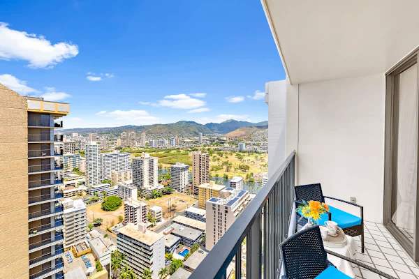 Relax on the balcony with city and mountain views in this modern high-rise apartment.