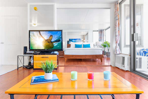 bright living area with a modern wooden bed and large windows for natural light