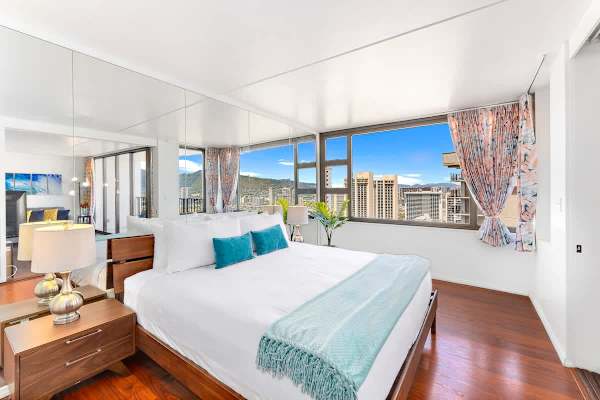 Bright bedroom with city views and modern wooden flooring