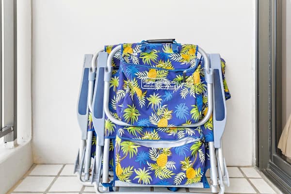 Folded tropical-print beach chairs ready for outdoor relaxation.