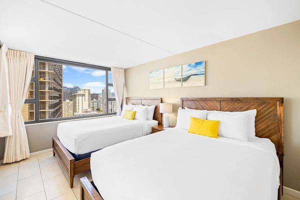 Rest easy in your bright bedroom featuring 2 queen beds with stylish wood headboards and a huge window offering a panoramic city view.