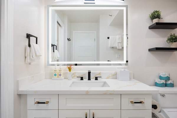 Experience a spa-like start to your day with a stunning backlit LED mirror and a sleek, marble-style designer vanity.