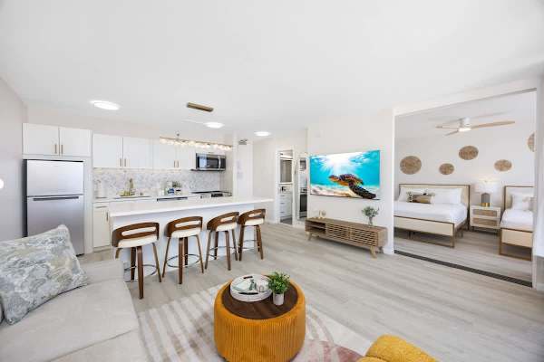 Discover a seamless blend of style and function in this open-concept suite, featuring a fully-equipped kitchen, chic lounge, and a bright, inviting bedroom separated by a sliding door.