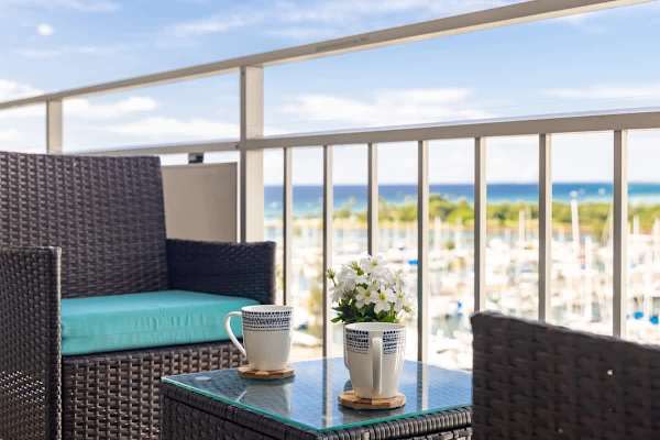 Enjoy a stunning panoramic view of the sparkling harbor, marina, and ocean from your private balcony with comfortable outdoor seating.