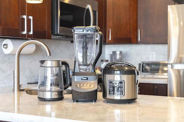 Essential kitchen trio: a sleek kettle, Ninja blender, and Aroma rice cooker ready for your next culinary adventure.