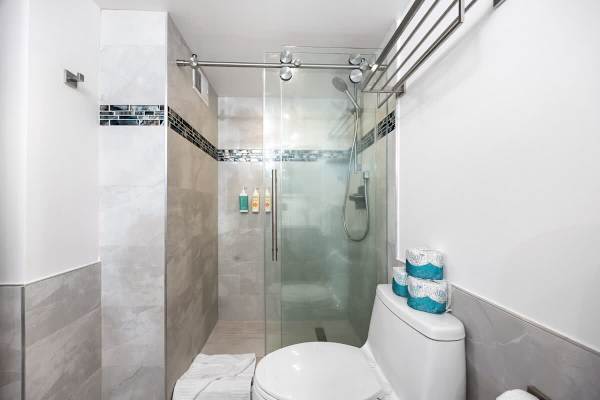 Your bathroom features a walk-in shower with a glass door for your convenience.