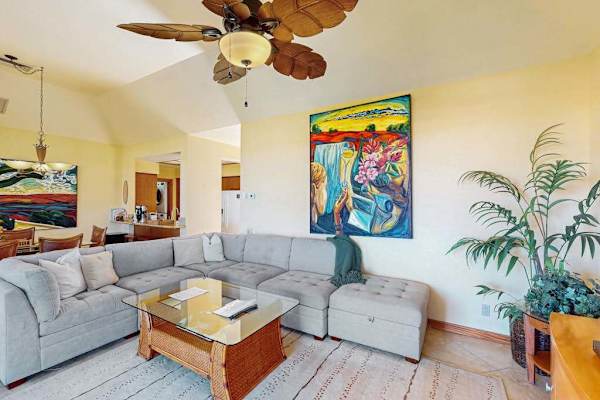 Plush Sectional Lounge with Tropical Ceiling Fan & Vibrant Artwork