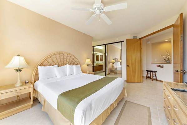Bedroom offers bedding, bedside tables, ceiling fan, artwork, and windows