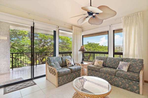 Floor-to-ceiling glass frames stunning views from this inviting open living room retreat