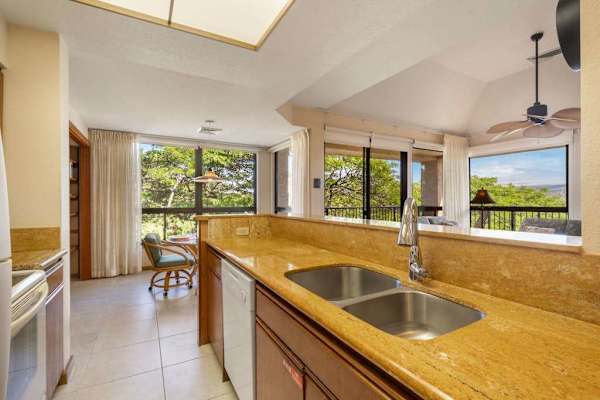 Kitchen workspace includes island counters, appliances, stools, windows, and artwork