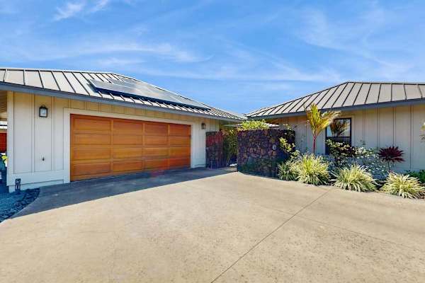 Modern Front Exterior with Wooden Garage Door, Solar Panels & Driveway