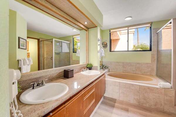 Ensuite bathroom includes soaking tub, vanity, mirrors, lighting, and tilework