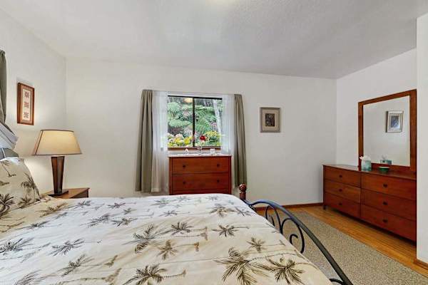 Spacious Primary Bedroom with Botanical Print Bedding, Dresser & Mirror