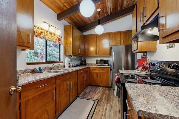 Fully Equipped Kitchen with Wooden Cabinets and Stainless Steel Refrigerator