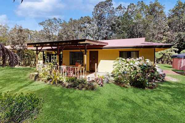 Front Exterior View of Single-Story Yellow Cottage with Covered Porch