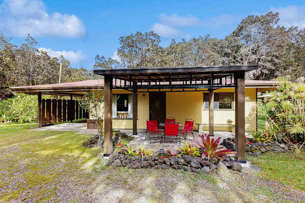 Covered Outdoor Patio Space with Dining Table, Red Chairs & Rock Garden